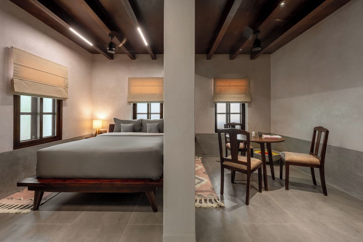 A bedroom with a bed, bedside tables, and a window with a blind.