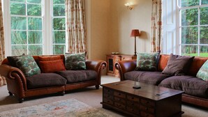 A living room with two brown leather sofas, a wooden coffee table, and a lamp. -  Hillside House , 18th century secluded country house with hot tub & gardens. (Dunfermline)