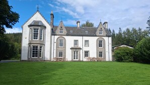 A large, white, two-story building with a symmetrical facade, multiple chimneys, and a well-maintained lawn in front. -  Hillside House , 18th century secluded country house with hot tub & gardens. (Dunfermline)