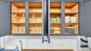 Eine Küche mit einem eingebauten Schrank, der Weingläser, Schüsseln und Teller beherbergt.