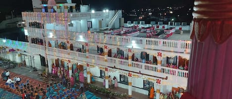 A multi-story building with balconies, a stage, and a crowd of people.