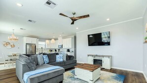 A modern living room with a sectional sofa, a wooden coffee table, and a large rug. - Lake2Sea - Spacious Retreat, Gulf & Waterway View! (Surfside Beach)
