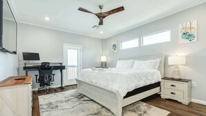 A bedroom with a bed, desk, chair, and a ceiling fan. - Lake2Sea - Spacious Retreat, Gulf & Waterway View! (Surfside Beach)