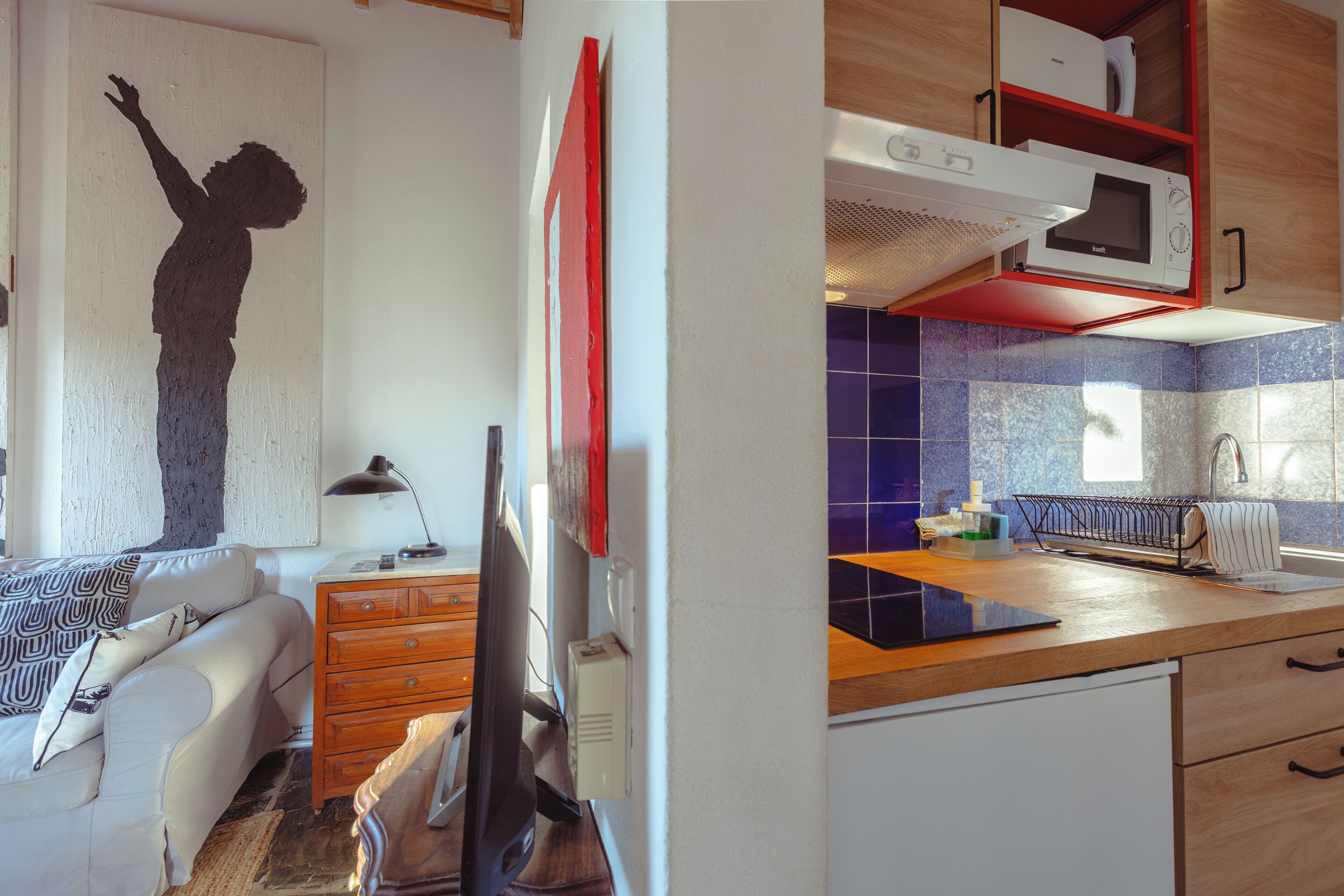A compact living space with a kitchenette, a dining area, and a bedroom.