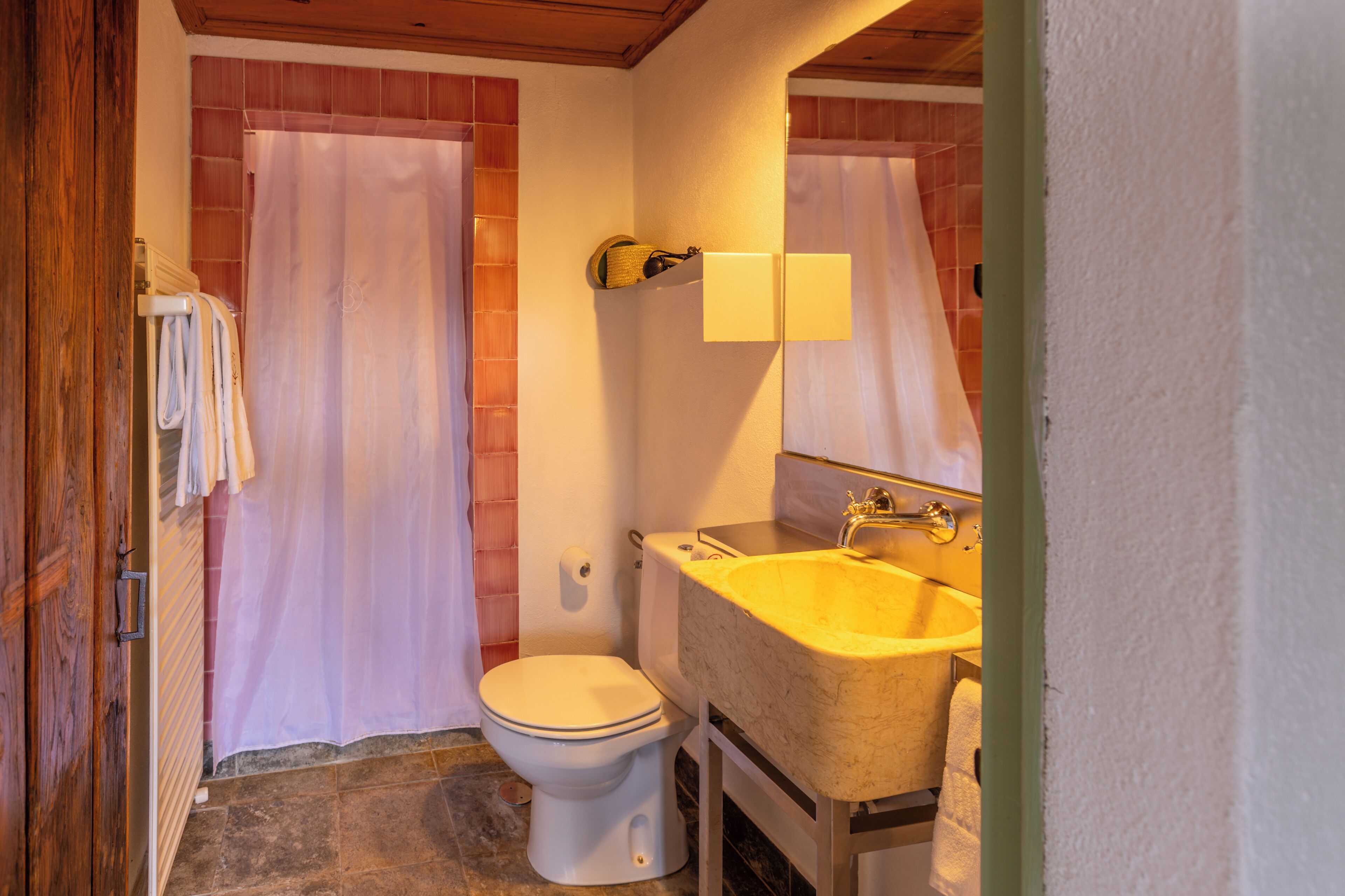 A bathroom with a toilet, sink, and shower curtain.