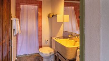 A bathroom with a toilet, sink, and shower curtain.