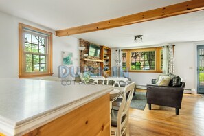 A spacious kitchen with a large island, wooden beams, and a view of the outdoors. - Easy drive to Scarborough Beach. Located in Briggs Farm (Narragansett)