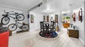 Uma sala de estar espaçosa com uma mesa de jantar, cadeiras e um suporte para bicicletas.