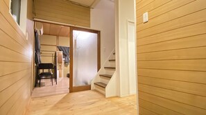 Un estrecho pasillo de madera con una escalera que conduce a una habitación.