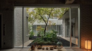 A modern interior with a view of a courtyard, featuring a table with various bowls and a vase. - KÚON Hakone Gora (Hakone)