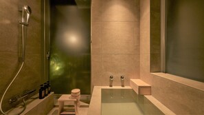 A modern bathroom with a glass-enclosed shower, a bathtub, and a small wooden stool. - KÚON Hakone Gora (Hakone)