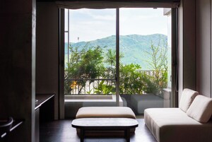 Una habitación con un ventanal grande, un sofá y una pequeña mesa.