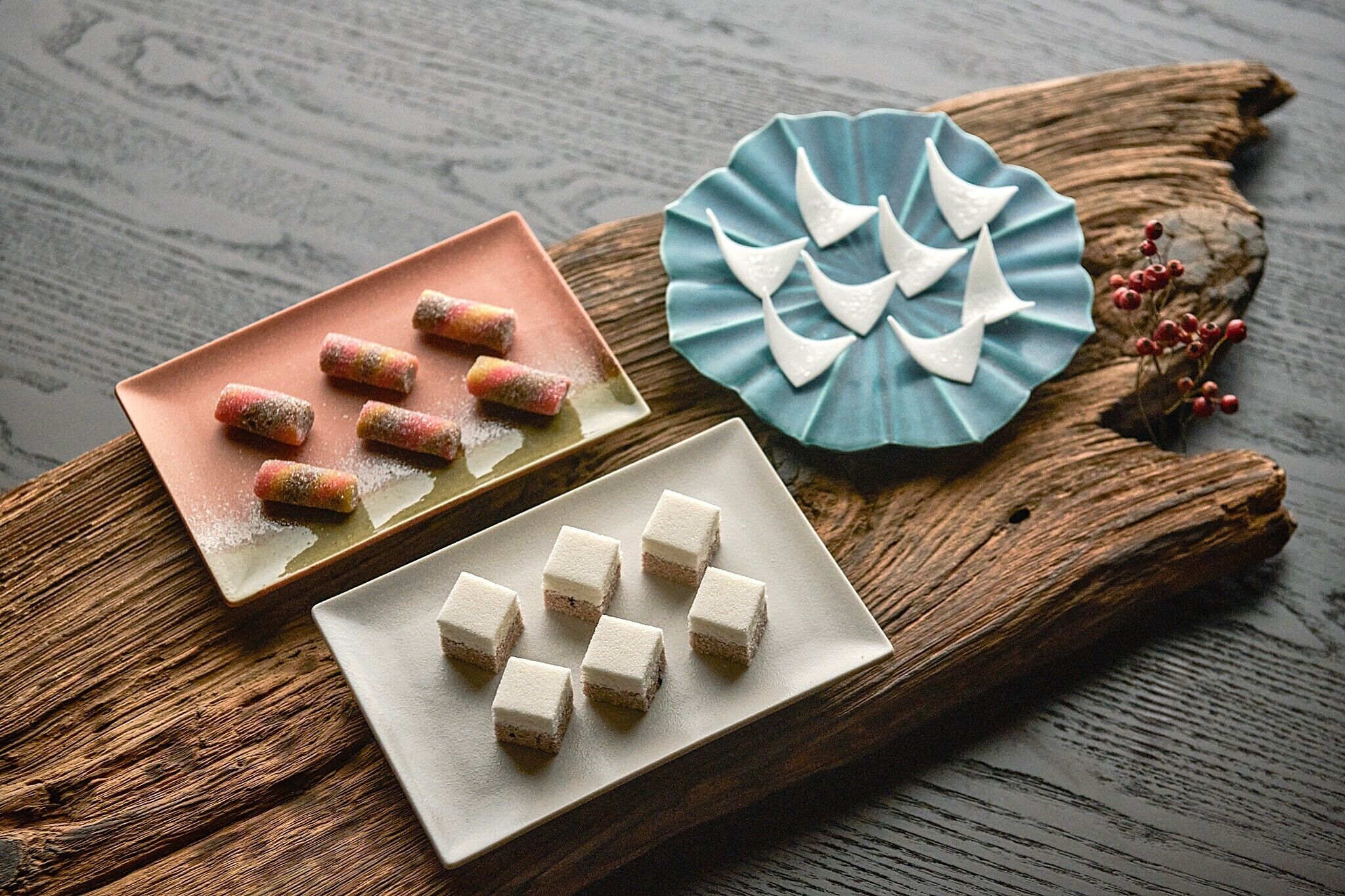 A wooden table with three plates of food.