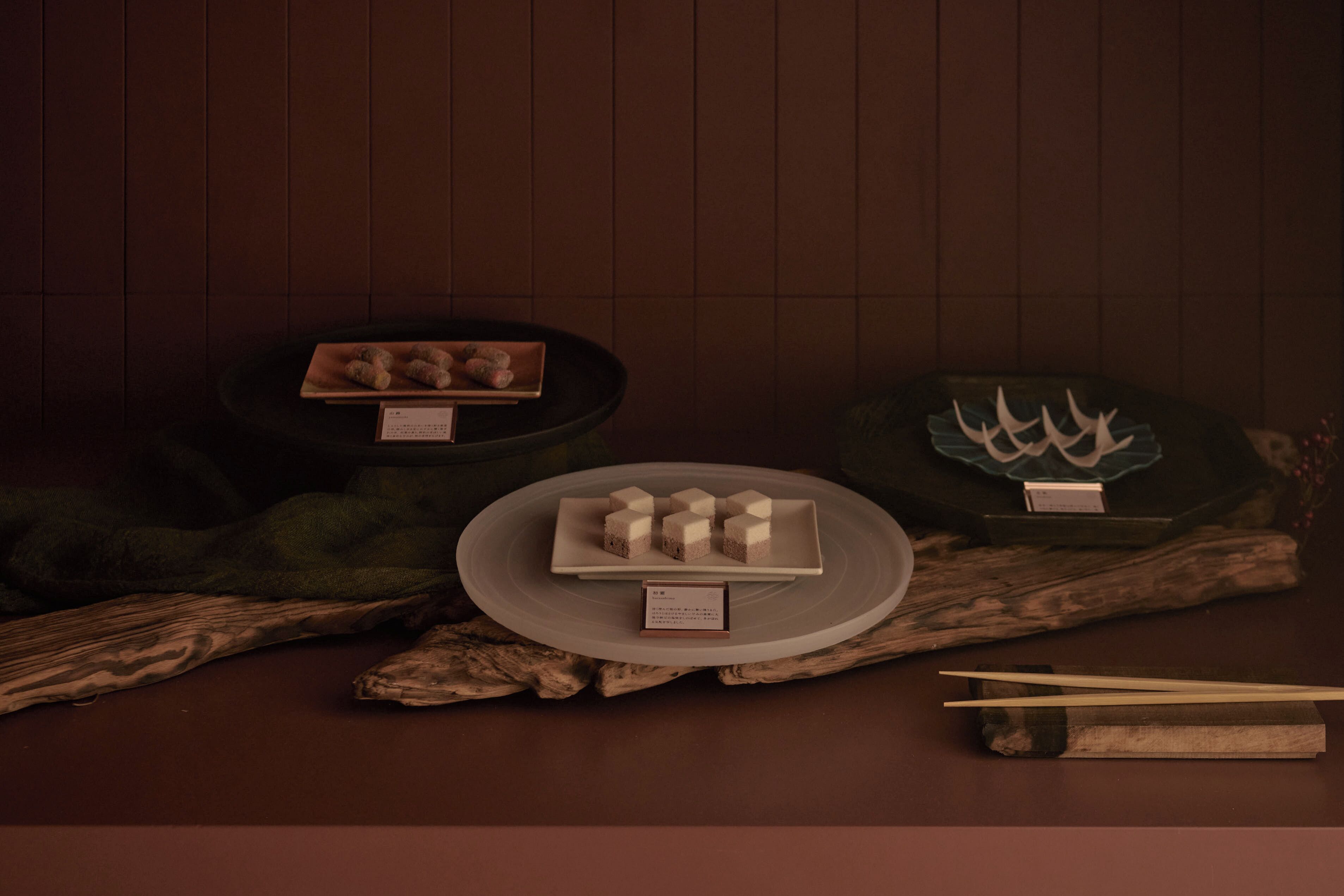 Une table avec une assiette de nourriture, des baguettes et un menu.