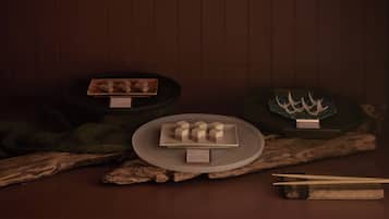 Une table avec une assiette de nourriture, des baguettes et un menu.