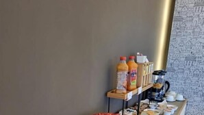 Un bufé de desayuno con una variedad de pasteles, un pastel bundt, muffins y botellas de jugo.