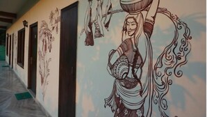 Un pasillo con un mural de una mujer sosteniendo una olla y un niño, puertas y suelo de mármol.