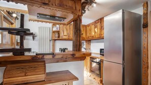Una cucina con mobili in legno, un frigorifero in acciaio inossidabile e un forno integrato.