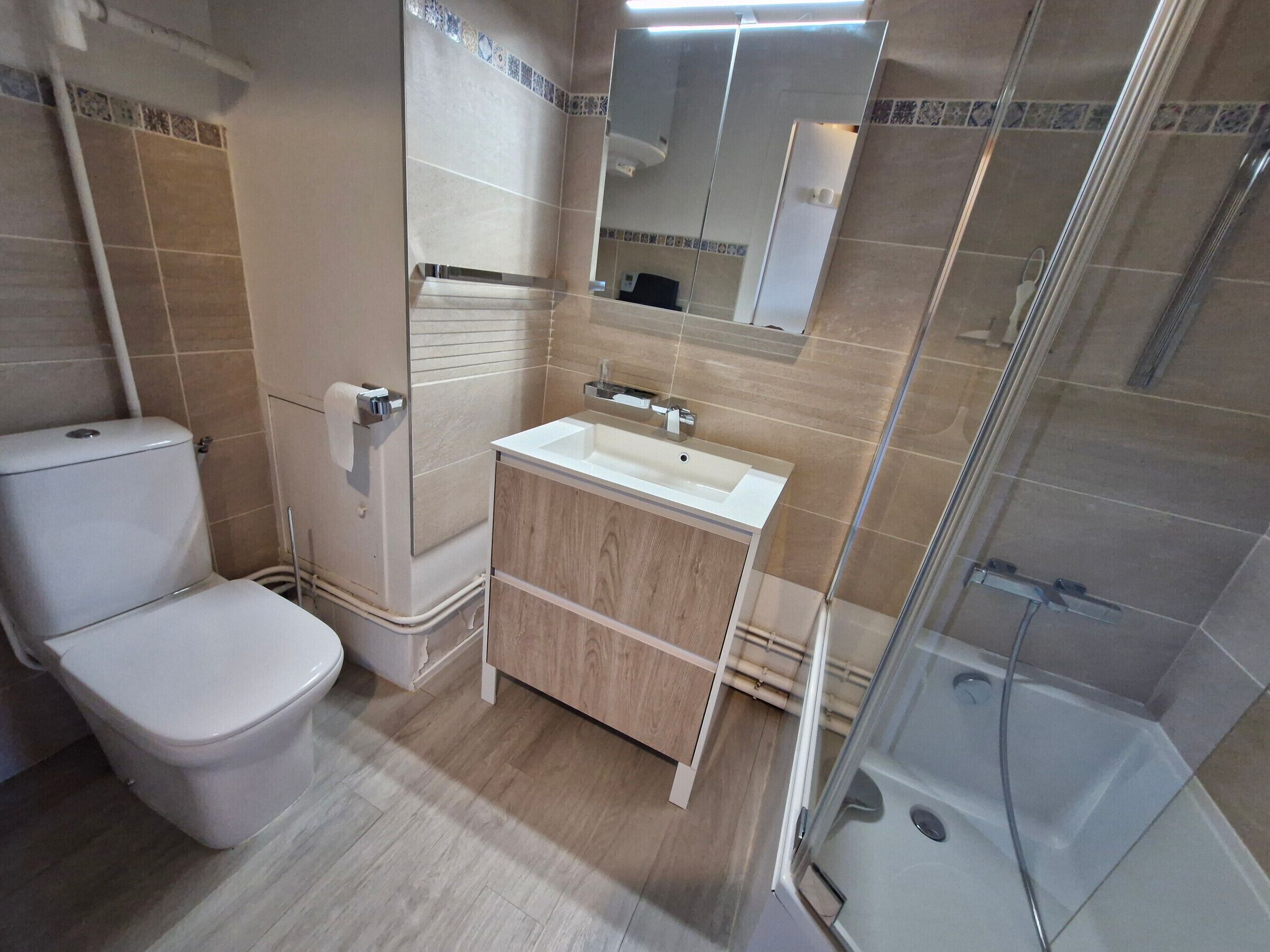 Une salle de bain moderne équipée de toilettes, d’un lavabo et d’une douche.