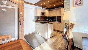 Eine moderne Küche mit Holzschränken, einer Kochinsel und einer Wand mit Steinverkleidung.