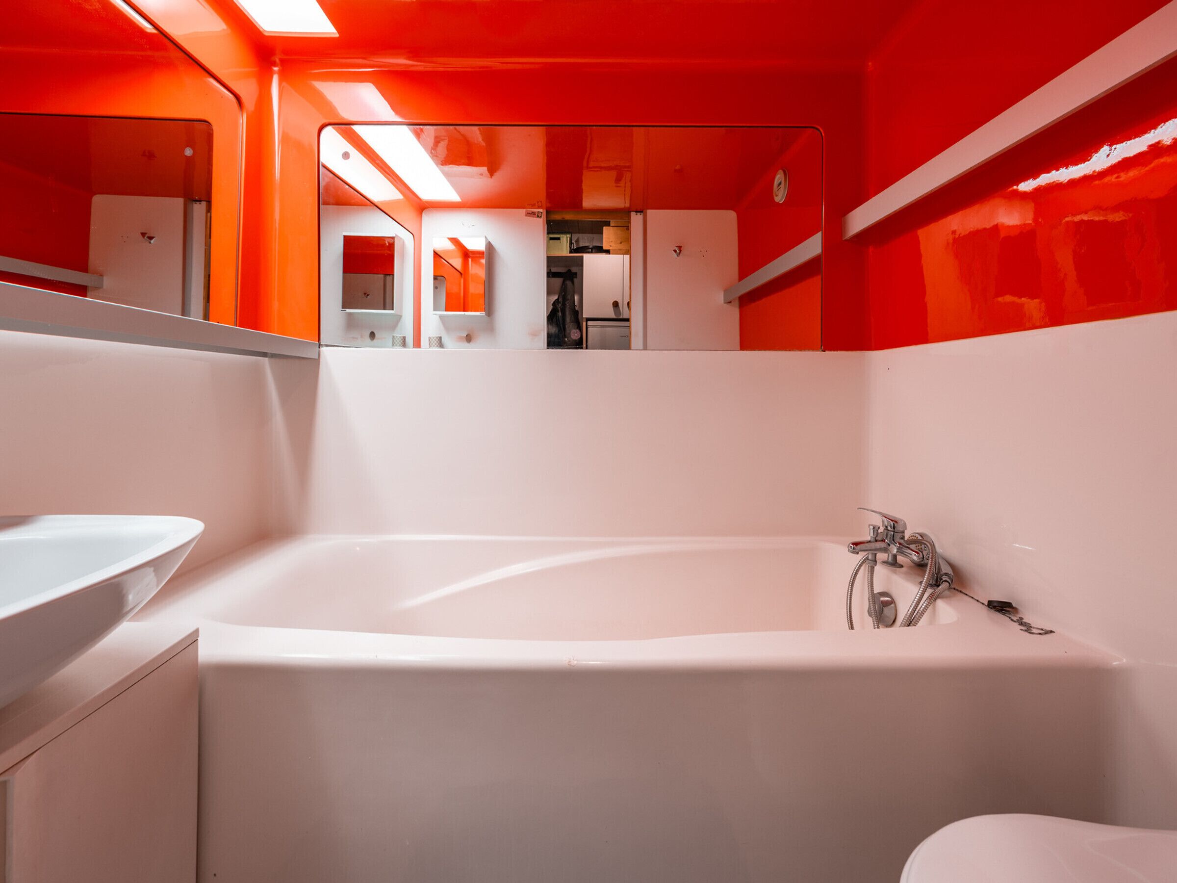 Une salle de bain moderne avec une baignoire blanche, un lavabo et un miroir.