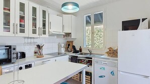A modern kitchen with white cabinets, a built-in oven, a microwave, and a dishwasher. - Villa in Vieux-Boucau for 10, near ocean, with terrace (Vieux-Boucau-les-Bains)