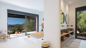 Un interior moderno con un amplio ventanal corredera que da a un balcón con vistas al mar.