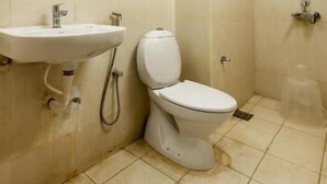 Un baño pequeño con inodoro, lavamanos y ducha.
