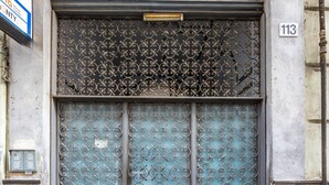 A building entrance with a decorative metal gate, a mailbox, and a number sign. - Solaris Suites  (Naples)