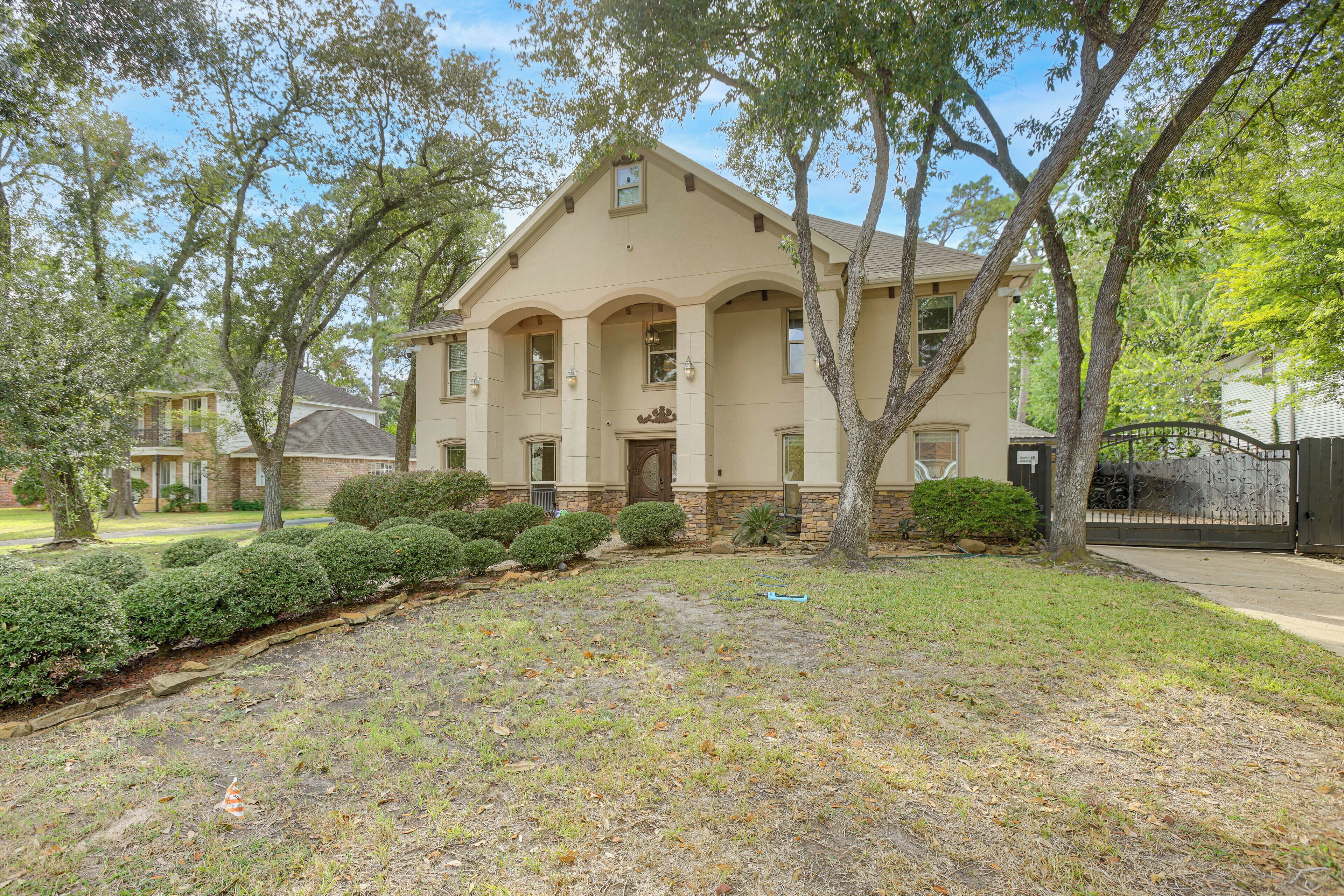 A two-story house with a symmetrical facade, multiple windows, and a front porch.