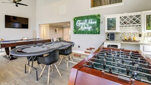 A spacious room with a foosball table, a pool table, and a television mounted on the wall. - Heated Pool, Hot Tub, Game Room: Houston Group Gem (Houston)