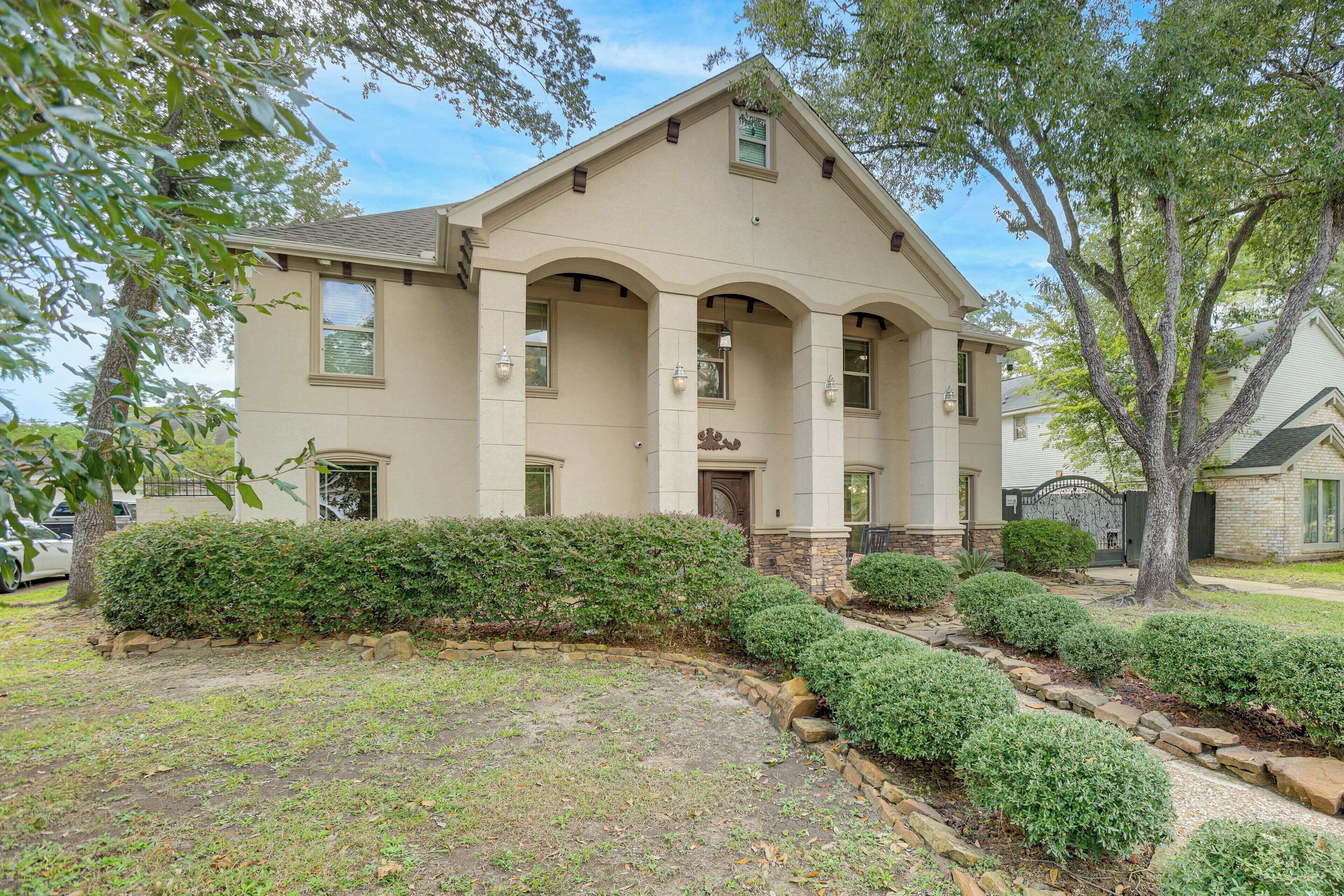 A two-story house with a symmetrical facade, a central entrance with a door, and a small porch area.