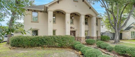 A two-story house with a symmetrical facade, a central entrance with a door, and a small porch area.