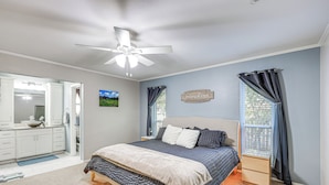 A bedroom with a bed, a ceiling fan, a window with curtains, a bedside table, and a wall-mounted sign. - Work, Explore & Unwind: Convenient San Antonio Gem (San Antonio)