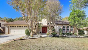 A single-story house with a garage, a front door, and a small front yard with trees and shrubs. - Work, Explore & Unwind: Convenient San Antonio Gem (San Antonio)