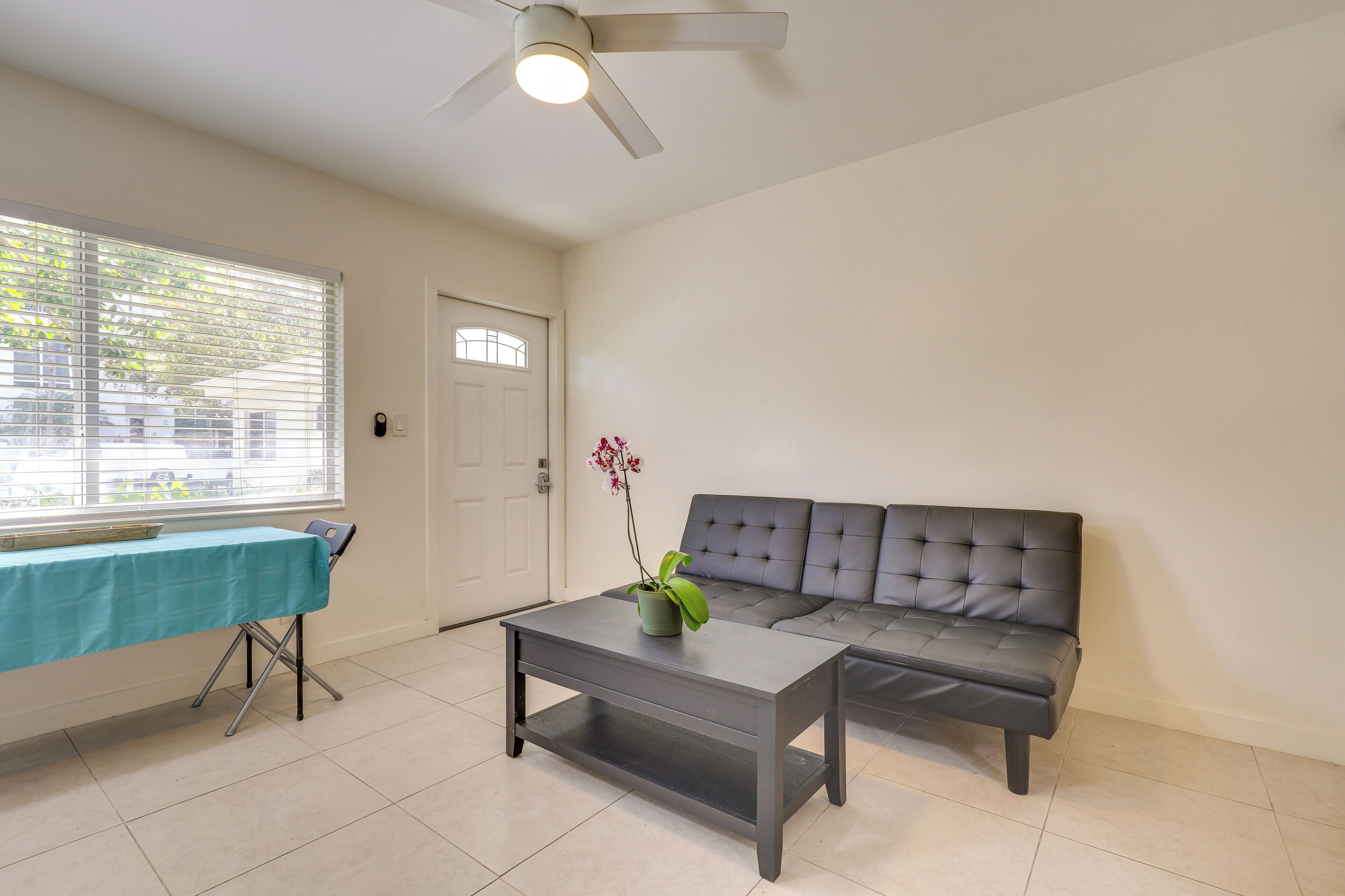 A living room with a sofa, a coffee table, and a table with a tablecloth.