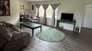 A living room with a sofa, a coffee table, a TV, and a window with curtains. - Close to Notre Dame Family And Pet Friendly  house Heat AC  

Located in Elkhart (Elkhart)