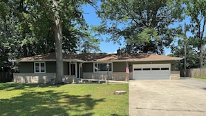 A residential house with a garage, a lawn, and a tree in front. - Close to Notre Dame Family And Pet Friendly  house Heat AC  

Located in Elkhart (Elkhart)