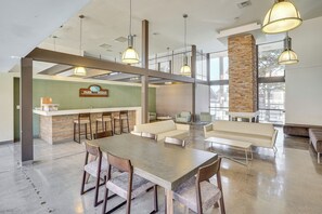 Un vestíbulo amplio con una mesa de recepción, zona de estar y una mesa grande.