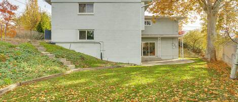 A two-story house with a front yard covered in fallen leaves.