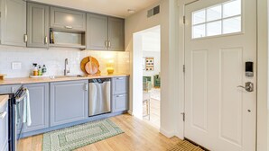 Una cocina moderna con gabinetes grises, lavavajillas y microondas.
