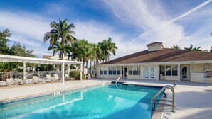 A swimming pool with lounge chairs, palm trees, and a covered area. - Walk to Canova Beach Park: Couple's Coastal Condo (Indialantic)