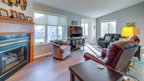 A living room with a fireplace, a television, a sofa, and a chair. - Work & Play: Pet-friendly Fargo Home 6 Mi to Dtwn (Fargo)