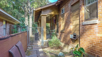 A residential property with a brick exterior, a covered patio area, and a visible window.
