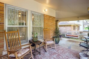 A covered patio area with two wooden chairs, a small table, and a potted plant. - < 1 Mi to Dtwn Texarkana: Couple's Retreat w/ Yard (Texarkana)