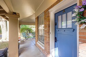 A covered porch with a blue door, a brick wall, and a window. - < 1 Mi to Dtwn Texarkana: Couple's Retreat w/ Yard (Texarkana)