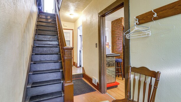 A staircase leading to a second floor, a wooden chair, and a wall-mounted clothes hanger. - 5 Mi to the Jumonville Cross: Home w/ Fenced Yard (Uniontown)