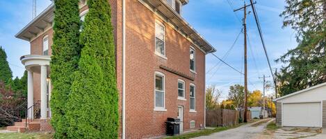 Un bâtiment en briques de deux étages, doté d’un porche couvert et d’un garage.