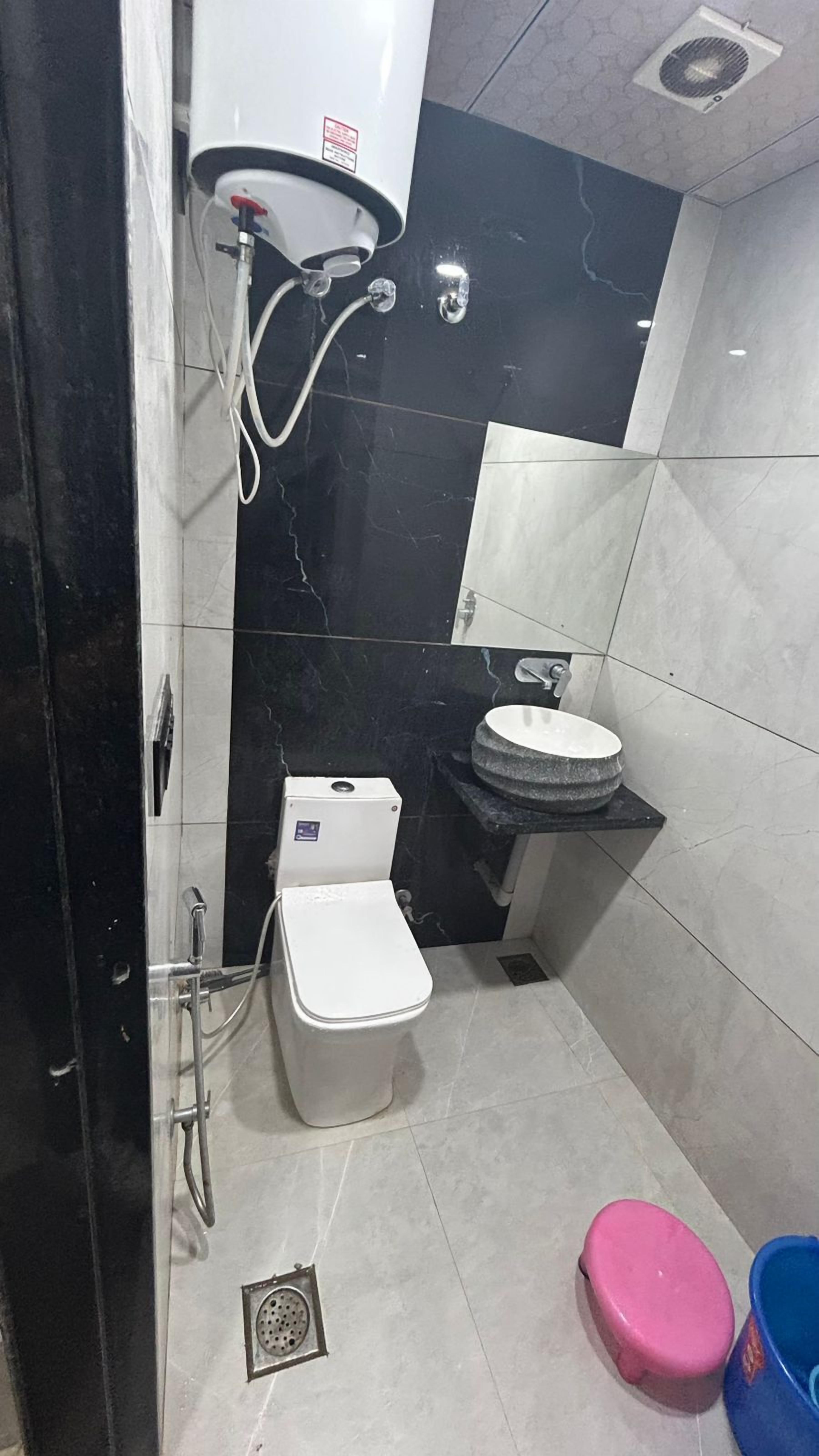 A small bathroom with a toilet, sink, and shower.