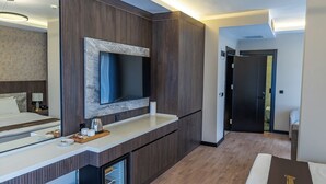 A modern hotel room with a large bed, a built-in TV, a minibar, and a large mirror. - ROSSA MARIN HOTEL (Darica)